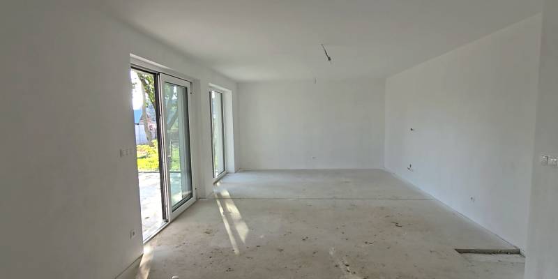 4 izbový BUNGALOV novostavba (VYSTAVBA) Piešťany, kvalitné prevedenie - Priestranná miestnosť v rodinnom dome s veľkými oknami a betónovou podlahou.