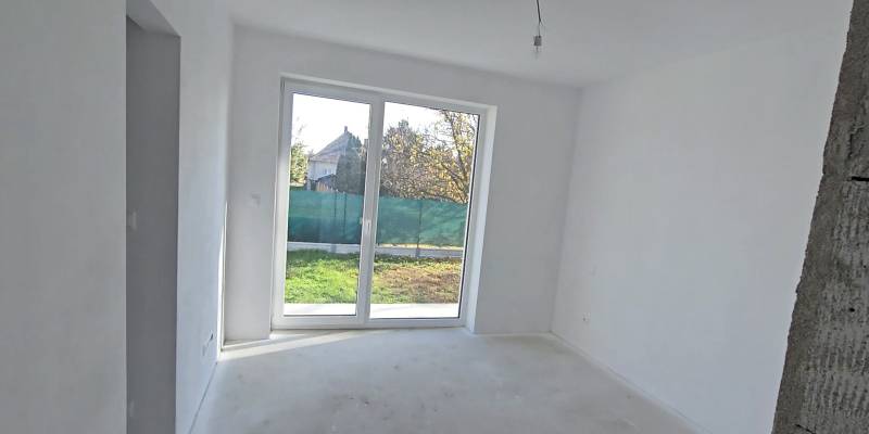 4 izbový BUNGALOV novostavba (VYSTAVBA) Piešťany, kvalitné prevedenie - Biela miestnosť s veľkým oknom a výhľadom na záhradu v rodinnom dome.
