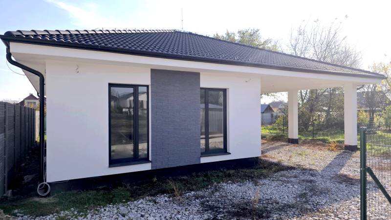 4 izbový BUNGALOV novostavba (VYSTAVBA) Piešťany, kvalitné prevedenie - Rodinný dom v Piešťanoch s bielou fasádou, tmavou strechou a kamienkovým nábehom.