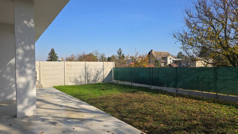 4 izbový BUNGALOV novostavba (VYSTAVBA) Piešťany, kvalitné prevedenie - Záhrada rodinného domu v Piešťanoch s trávnikom, betónovou terasou a oplotením.