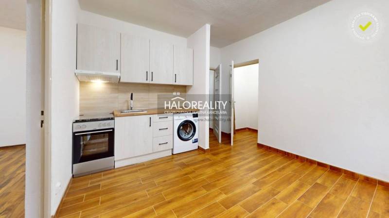 Predaj, jednoizbový byt Lučenec - EXKLUZÍVNE HALO RE... - Kuchyňa v 1-izbovom byte s podlahou s dreveným dekorom a bielymi skrinkami.