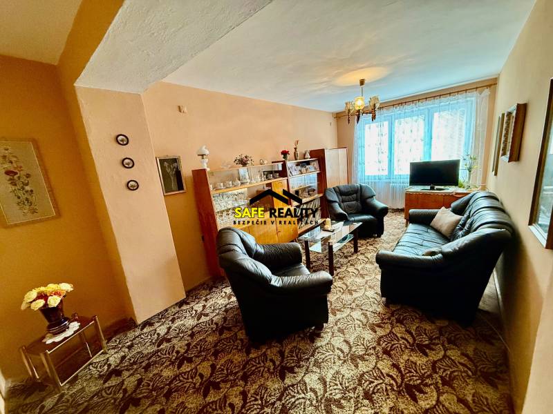 Dvojizbový byt v pôvodnom stave, Považská Bystrica - Obývačka v 2-izbovom byte so sedacou súpravou a presklenou vitrínou.