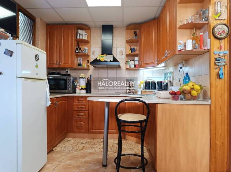 Predaj, chata Byšta - EXKLUZÍVNE HALO REALITY - Kuchyňa v chate s dreveným dekorom, barovým pultom a spotrebičmi.