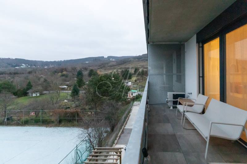 Slnečný 1,5i byt s loggiou a parkovaním - Balkón na 1-izbovom byte, výhľad na prírodu, pohľad na záhrady a stromy.