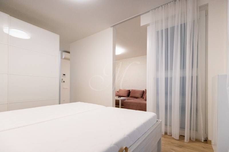 Zariadený 2i byt s lodžiou v rezidencii Pri Mýte - Dvojizbový byt s posteľou, podlahou s dreveným dekorom a delenou obývacou časťou.