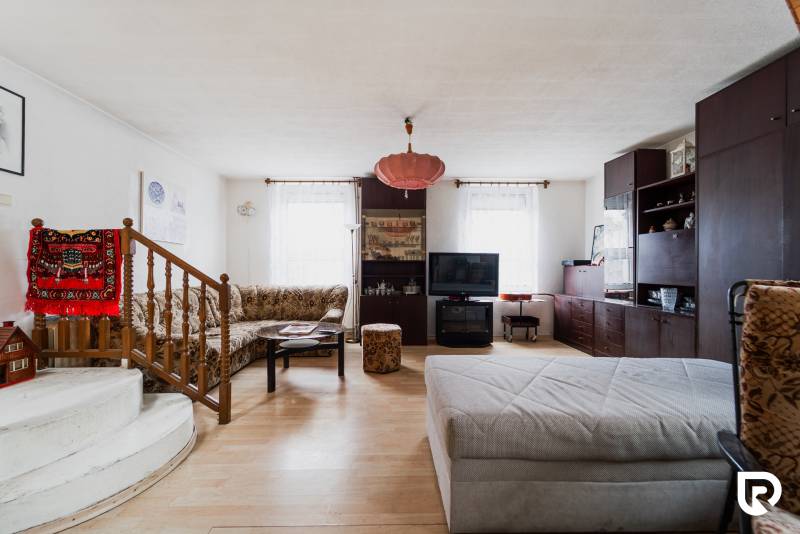 Pozemky s dvoma domami na prestavbu alebo novostavbu - Obývacia izba v rodinnom dome s podlahou s dreveným dekorom a pohodlným posedením.