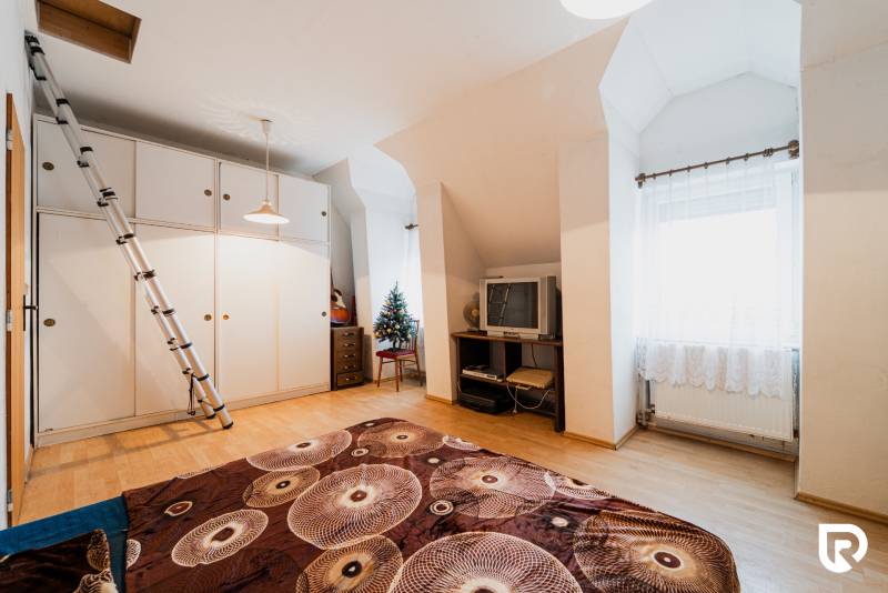 Pozemky s dvoma domami na prestavbu alebo novostavbu - Izba v rodinnom dome s podlahou s dreveným dekorom, televízorom a skriňou.