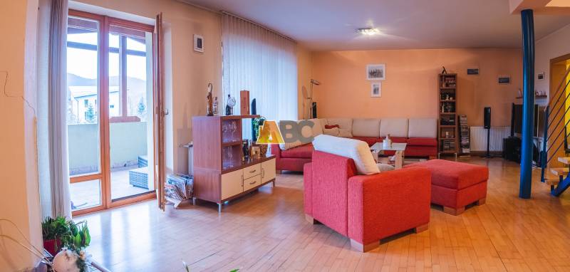 Obrovská vila pre luxusný život aj podnikanie (pripravujeme) - Obývacia izba vo vile s červenou sedačkou a podlahou s dreveným dekorom.