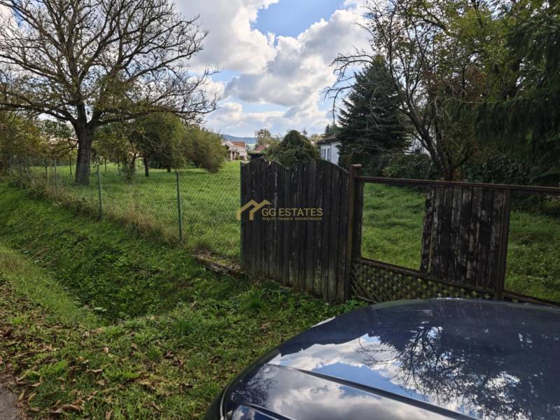 Predaj krásny pozemok pri Malej Domaši - Pozemky - bývanie na ulici Malá Domaša vo Vranove nad Topľou, oplotená zelená plocha so stromami.