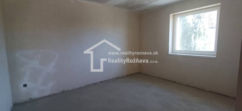 PREDAJ/ Kompletne zrekonštruovaný rodinný dom v Rožňave - Prázdna izba s betónovou podlahou a veľkým oknom v rodinnom dome.
