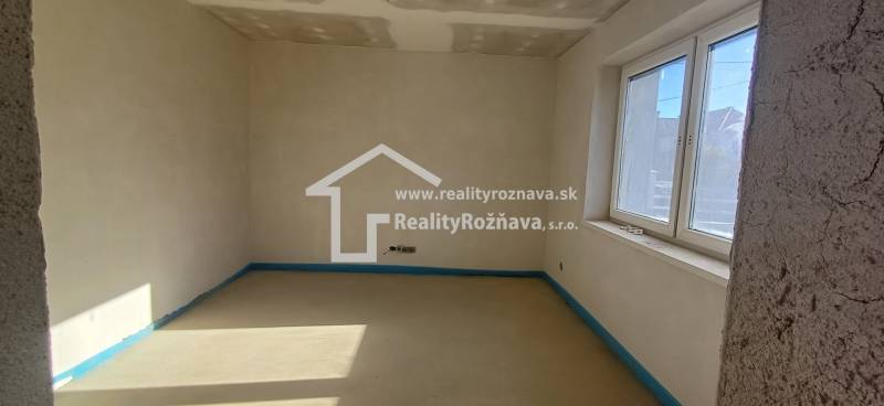 PREDAJ/ Kompletne zrekonštruovaný rodinný dom v Rožňave - Prázdna miestnosť v rodinnom dome s oknom a nedokončenými stenami.