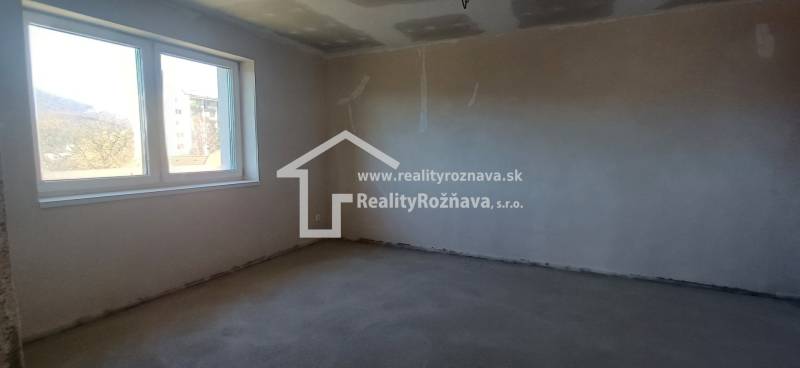 PREDAJ/ Kompletne zrekonštruovaný rodinný dom v Rožňave - Prázdna izba s oknom v rodinnom dome a s nerovnou stenou.