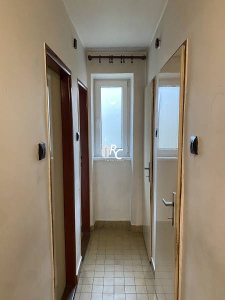 REZERVOVANÉ - Veľký 2-izbový byt s loggiou v centre Martina - Úzka chodba v 2-izbovom byte so svetlým obkladom na podlahe.