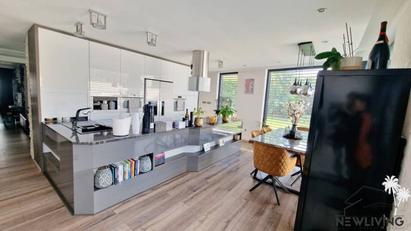 NADŠTANDARDNÝ 5 izbový dom Jánošíkova / Piešťany - Kuchyňa v rodinnom dome s podlahou s dreveným dekorom, jedálenský stôl, množstvo svetla.