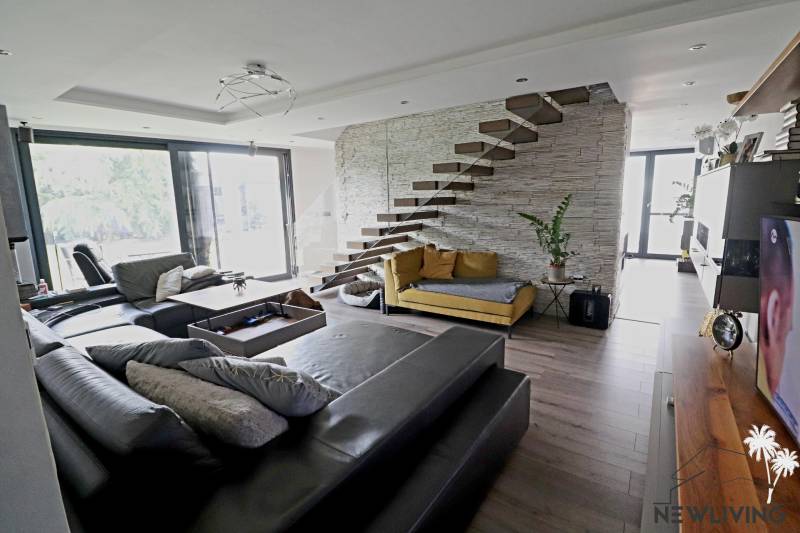 NADŠTANDARDNÝ 5 izbový dom Jánošíkova / Piešťany - Obývačka s pohodlnou sedačkou, otvoreným schodiskom a veľkými oknami, navrhnutá na ulici Jánošíkova.