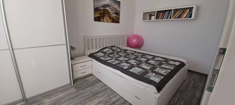 Na predaj 3izbový byt Tranovského , Dúbravka - Spálňa v 3-izbovom byte so šatníkom, posteľou, knihami a podlahou s dreveným dekorom.