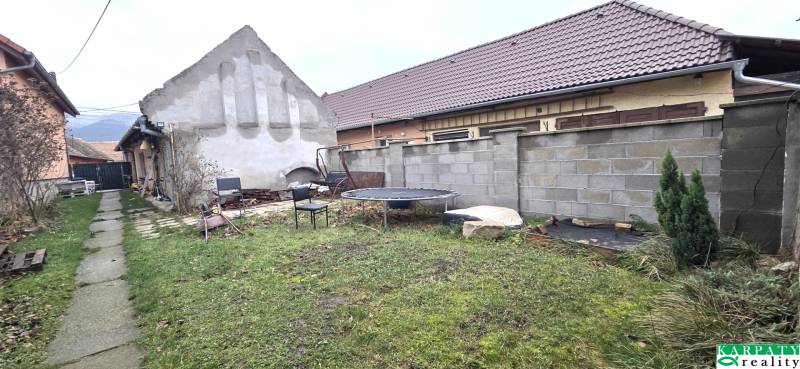 Na predaj 2 izbový rodinný dom, Dolné Orešany! - Záhrada pri rodinnom dome v Dolných Orešanoch s betónovým plotom a trampolínou.