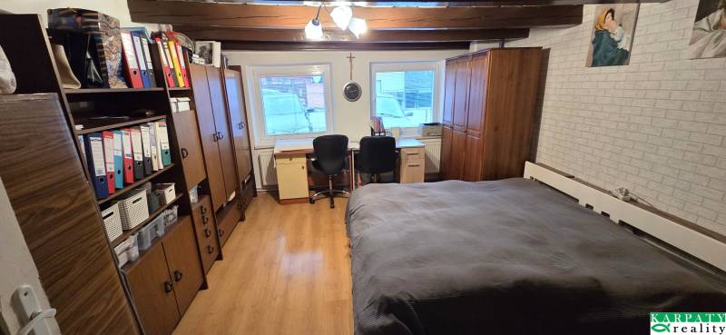 Na predaj 2 izbový rodinný dom, Dolné Orešany! - Izba v rodinnom dome s podlahou s dreveným dekorom, posteľou a kancelárskym kútom.