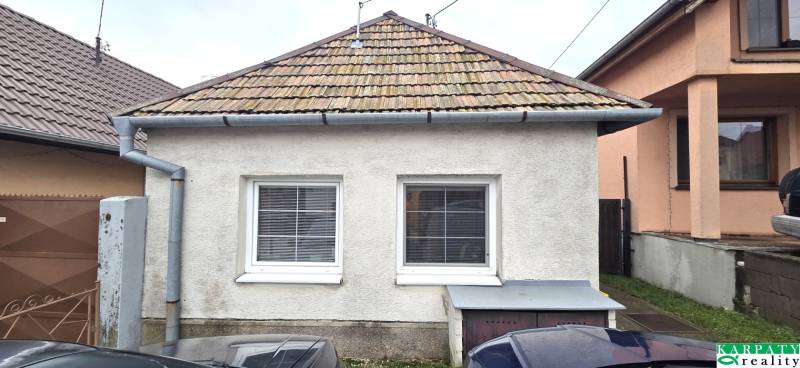 Na predaj 2 izbový rodinný dom, Dolné Orešany! - Rodinný dom v Dolných Orešanoch s klasickou strechou a dvomi oknami v popredí.
