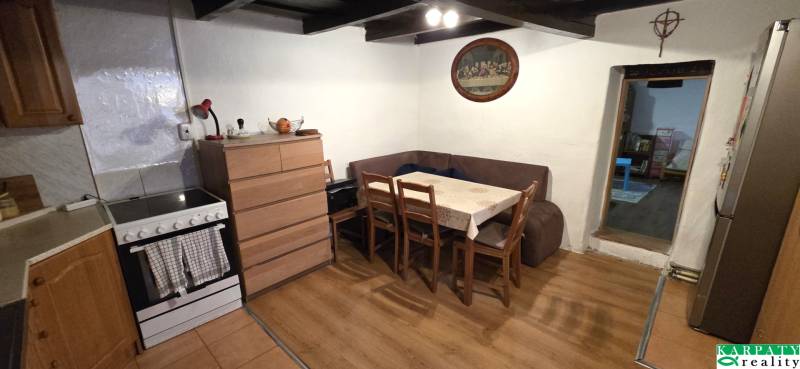 Na predaj 2 izbový rodinný dom, Dolné Orešany! - Kuchyňa v rodinnom dome s rohovou sedačkou a podlahou s dreveným dekorom.