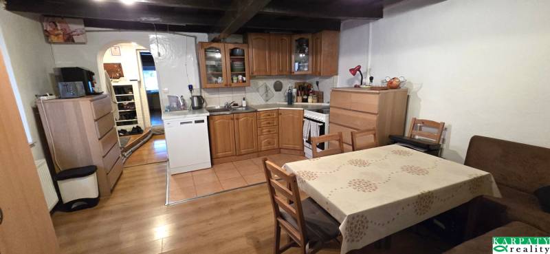 Na predaj 2 izbový rodinný dom, Dolné Orešany! - Kuchyňa s dreveným nábytkom a podlahou s dreveným dekorom v rodinnom dome.