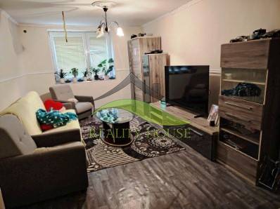 Rodinný dom na veľkorysom pozemku v Drahňove. - Obývacia izba v rodinnom dome s pohovkami a TV, podlaha s dreveným dekorom.