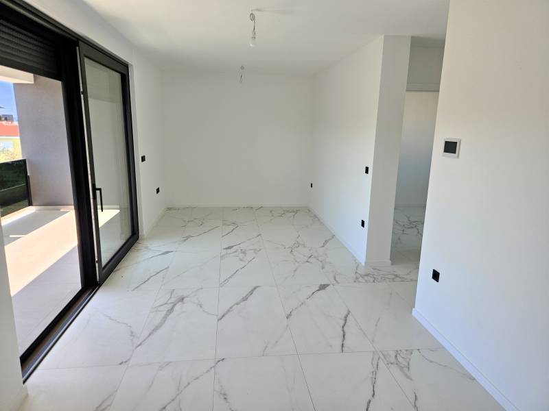 CHORVÁTSKO - Apartmány na ostrove VIR, Zadar - Interiér 3-izbového bytu s mramorovou podlahou a veľkými sklenenými dverami.