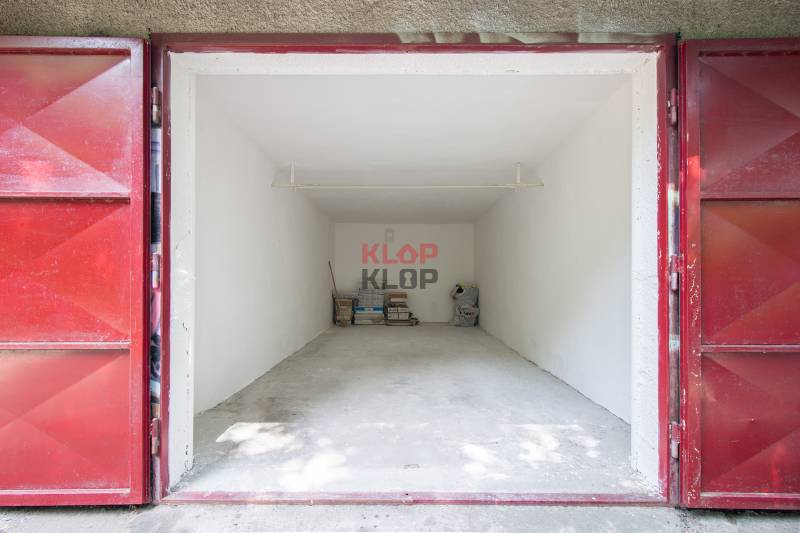 Pozrite si 17m², ZREKONŠTRUOVANÚ garáž, pri nemocnici Kramáre - Otvorená garáž so skladovanými predmetmi na ulici Opavská a Garáže, červené dvere.