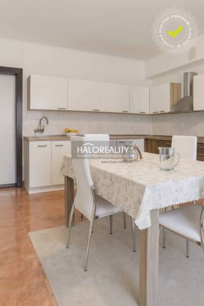 Predaj, rodinný dom Beša - Kuchyňa v rodinnom dome s bielou linkou a jedálenským stolom so štyrmi stoličkami.