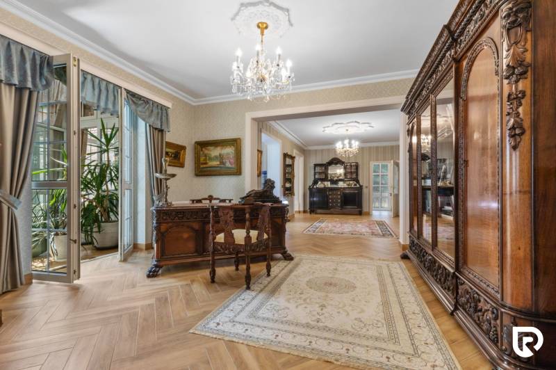 Exkluzívna honosná kúria | 3 ha pozemok | Dunakiliti - HU - Interiér so starožitným nábytkom, výraznými lustrami a podlahou s dreveným dekorom.