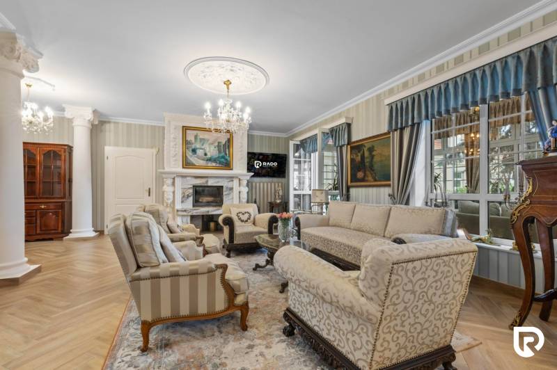 Exkluzívna honosná kúria | 3 ha pozemok | Dunakiliti - HU - Luxusný obývací priestor s krbom, zdobeným nábytkom a podlahou s dreveným dekorom.