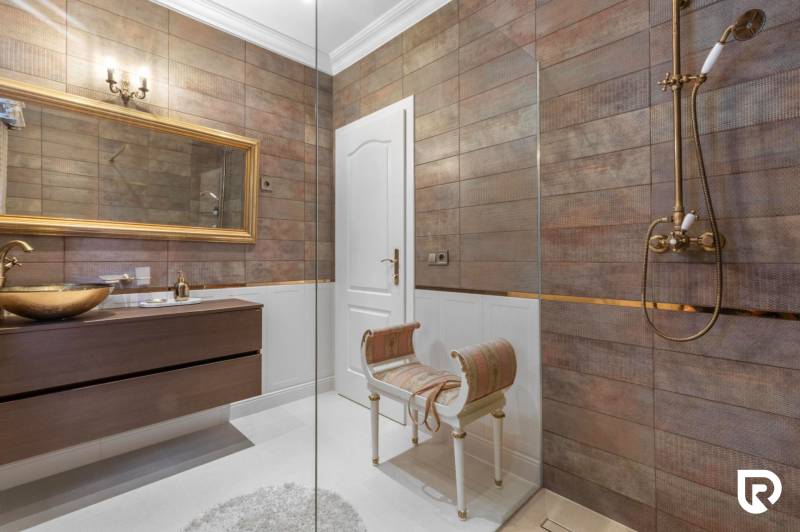 Exkluzívna honosná kúria | 3 ha pozemok | Dunakiliti - HU - Kúpeľňa so zlatým umývadlom, zrkadlom v ráme a dekoratívnou stoličkou.