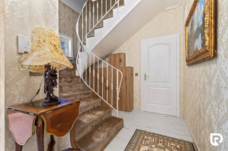 Exkluzívna honosná kúria | 3 ha pozemok | Dunakiliti - HU - Interiér so špirálovitým schodiskom, dekoratívnym stolíkom a štýlovým osvetlením. Zvláštne nehnuteľnosti.