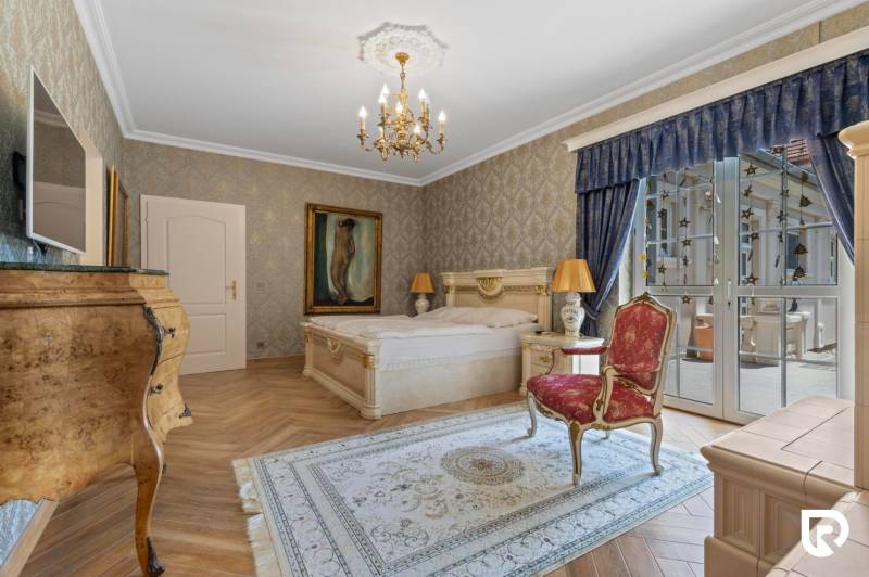 Exkluzívna honosná kúria | 3 ha pozemok | Dunakiliti - HU - Luxusná spálňa so zlatými prvkami, lustrom a podlahou s dreveným dekorom.