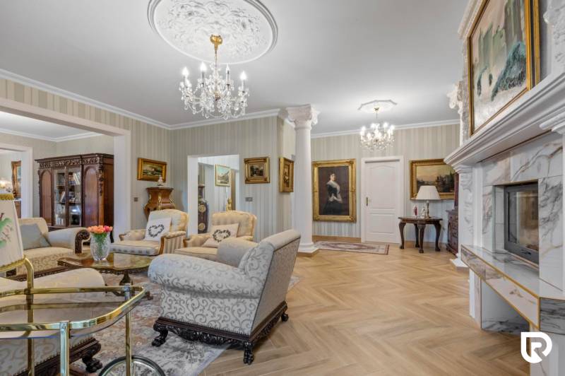 Exkluzívna honosná kúria | 3 ha pozemok | Dunakiliti - HU - Luxusný salón s krbom, sedacou súpravou a podlahou s dreveným dekorom.