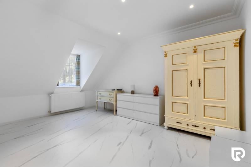 Exkluzívna honosná kúria | 3 ha pozemok | Dunakiliti - HU - Biele podkrovné miestnosti so starožitnou skriňou a podlahou s dreveným dekorom.