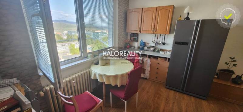 Predaj, jednoizbový byt Žiar nad Hronom, Novomeského - Kuchyňa v 1-izbovom byte so stolom, stoličkami a výhľadom z okna.