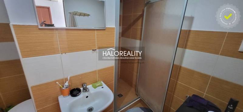 Predaj, jednoizbový byt Žiar nad Hronom, Novomeského - Kúpeľňa s umývadlom a sprchou v 1-izbovom byte, oranžovo-biele obklady.