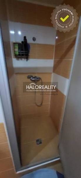 Predaj, jednoizbový byt Žiar nad Hronom, Novomeského - Sprchový kút v 1-izbovom byte s oranžovými dlaždicami a úložným priestorom na stene.