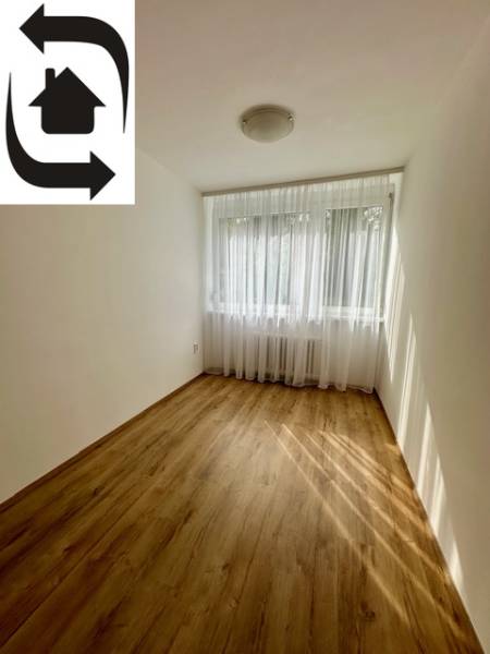 Prenájom 3 izbového bezbariérového bytu, Vetvová ulica, Bratislava - Izba s podlahou s dreveným dekorom v 3-izbovom byte, záclony na okne.