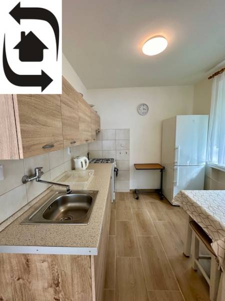 Prenájom 3 izbového bezbariérového bytu, Vetvová ulica, Bratislava - Kuchyňa v 3-izbovom byte s podlahou s dreveným dekorom a bielymi stenami.