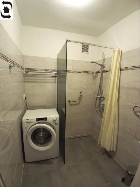 Prenájom 3 izbového bezbariérového bytu, Vetvová ulica, Bratislava - Kúpeľňa so sprchovacím kútom, práčkou a svetlými obkladmi v 3-izbovom byte.