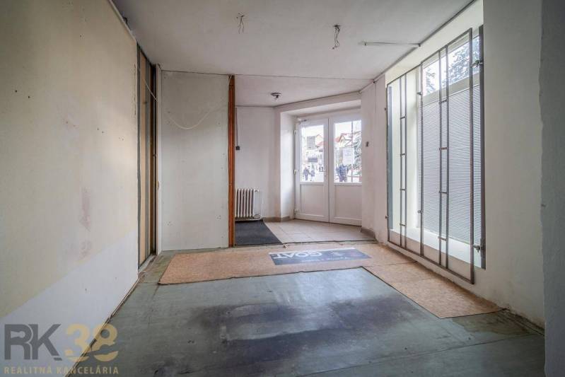 Exkluzívne: Predaj budovy v centre mesta Poprad - Interiér budovy so sklenenými dverami a matnými roletami, podlaha s kobercom.