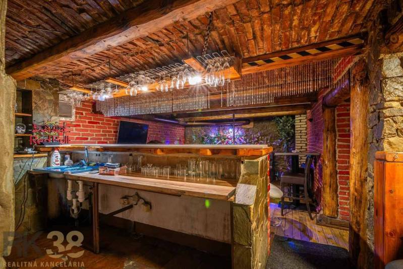 Exkluzívne: Predaj budovy v centre mesta Poprad - Kamenný bar s tehlovými stenami a podlahou s dreveným dekorom v budove.