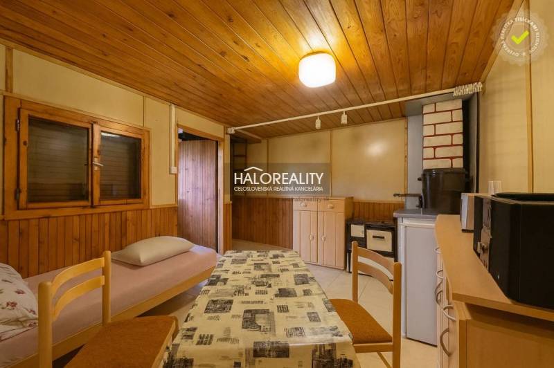 Predaj, záhradná chata Bytča, Veľká Bytča - ZNÍŽENÁ ... - Interiér so stolom, stoličkami a kreslom s látkovým poťahom, podlaha s dreveným dekorom.