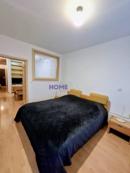 SLNEČNÝ KOMPLETNE ZARIADENÝ 2 IZB. BYT PRI ŠTRKOVECKOM JAZERE.  - Spálňa so širokou posteľou, nočnými stolíkmi a podlahou s dreveným dekorom v 2-izbovom byte.