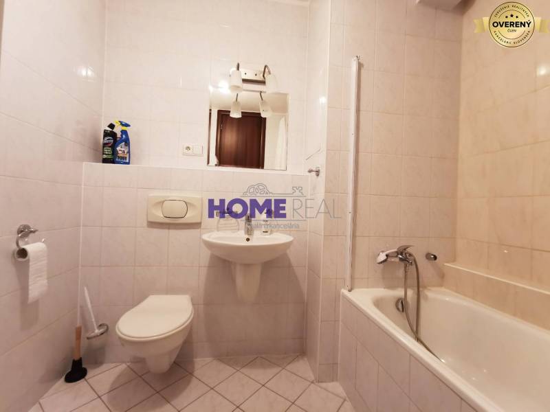 SLNEČNÝ KOMPLETNE ZARIADENÝ 2 IZB. BYT PRI ŠTRKOVECKOM JAZERE.  - Kúpeľňa v 2-izbovom byte s vaňou, umývadlom a toaletou, obložená bielymi dlaždicami.