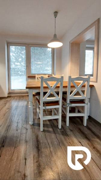 Predaj 3-izb bytu 75 m2 + garáž 18 m2, Trenčín - Pred poľom - Jedálenská časť s podlahou s dreveným dekorom v 3-izbovom byte s bielym nábytkom.