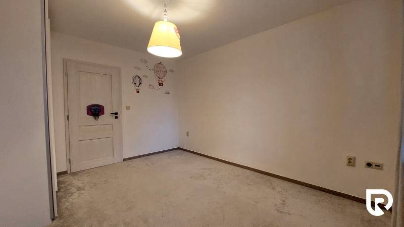 Predaj 3-izb bytu 75 m2 + garáž 18 m2, Trenčín - Pred poľom - Izba v 3-izbovom byte s kobercom, svetlou lampou a nástennými dekoráciami.