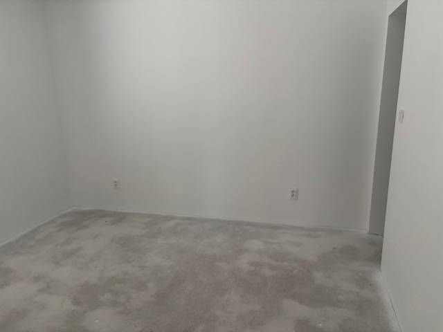 Na predaj dizajnový 4-izbový rodinný dom v Tomášove - Izba s bielymi stenami a nevýrazným kobercom v rodinnom dome.